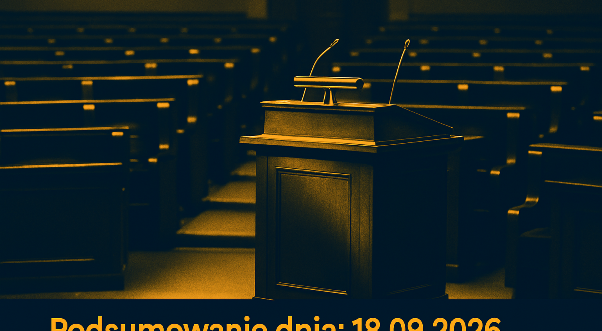 Pusta sala obrad parlamentu z mównicą, mikrofonami i rzędami miejsc dla posłów.