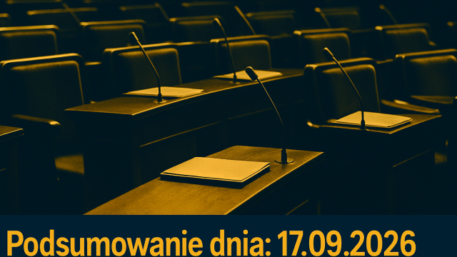 Pusta sala obrad parlamentu z ławami, mikrofonami i dokumentami.